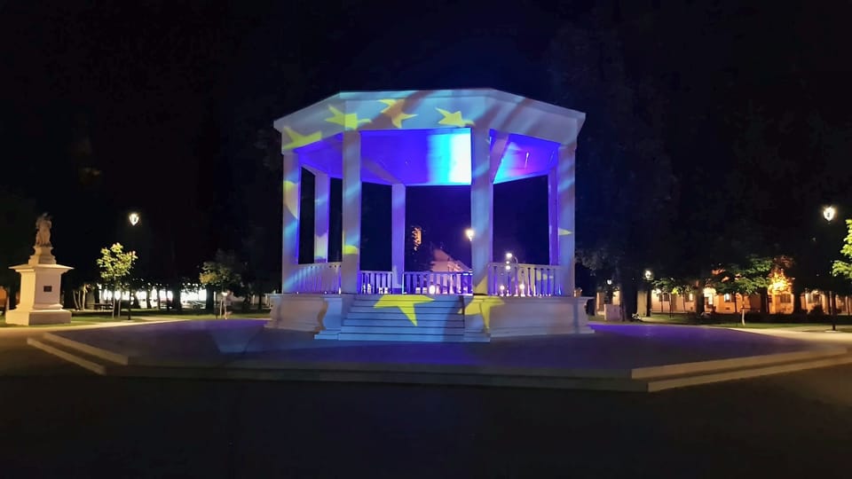 Noćni prizor paviljona u parku na koji su projicirane žute zvijezde na plavoj podlozi.
